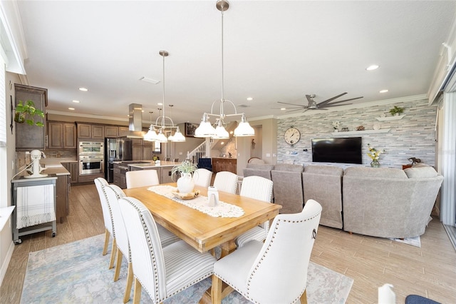 dining area featuring recessed lighting, ceiling fan with notable chandelier, crown molding, and light wood-style floors