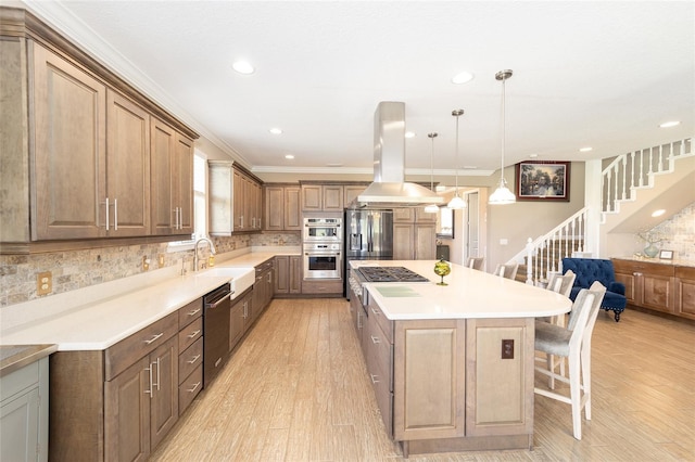 kitchen featuring a center island, a breakfast bar, appliances with stainless steel finishes, island exhaust hood, and light wood-style floors