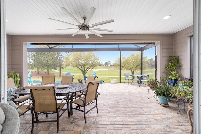 view of patio / terrace featuring a lanai, outdoor dining space, and ceiling fan