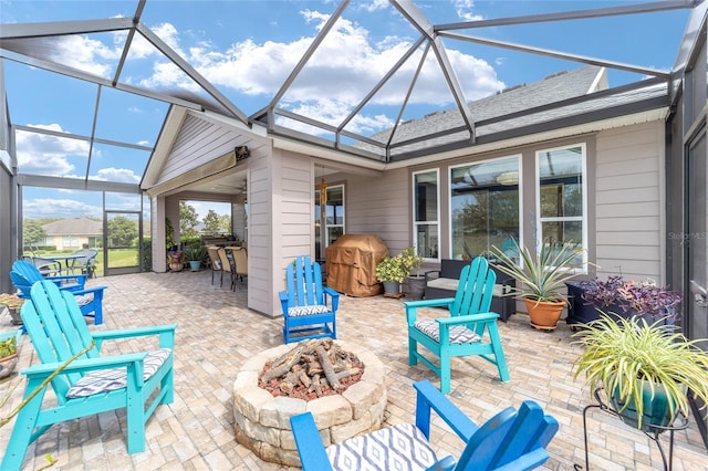 view of patio / terrace featuring a lanai, area for grilling, and a fire pit