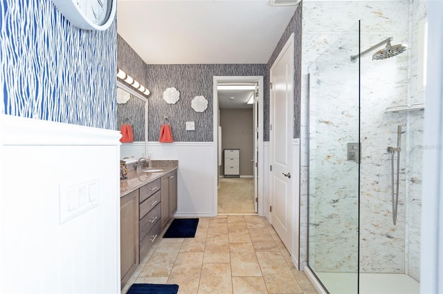 bathroom featuring a wainscoted wall, visible vents, a stall shower, tile patterned flooring, and vanity