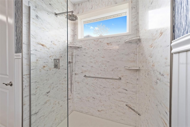 bathroom featuring a marble finish shower