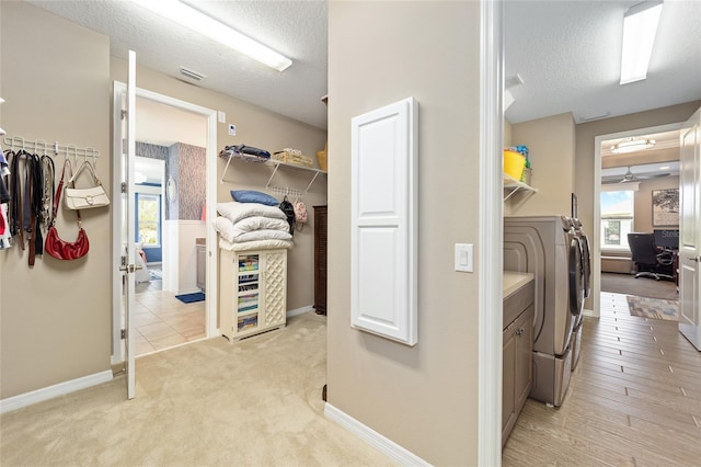 laundry area with washer and dryer, laundry area, baseboards, and a textured ceiling