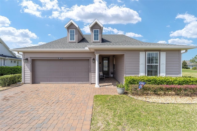 view of front of home featuring decorative driveway and a garage