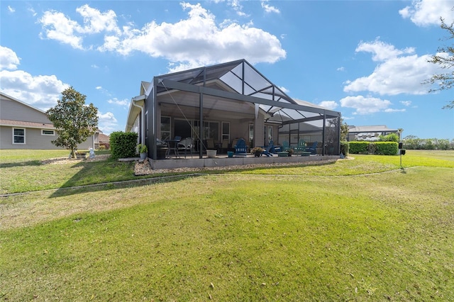 back of property with a patio area, a lawn, and glass enclosure