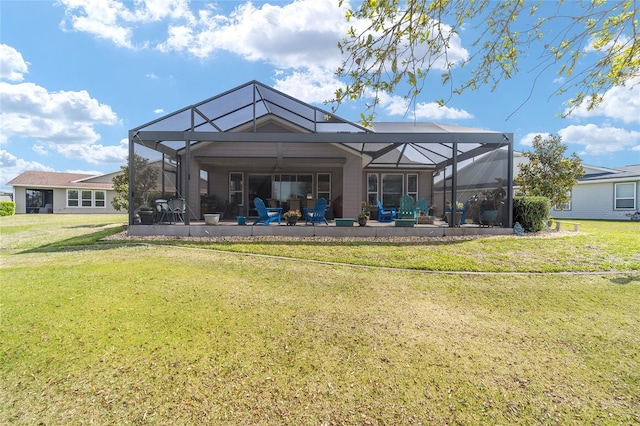 back of property with glass enclosure, a yard, and a patio area