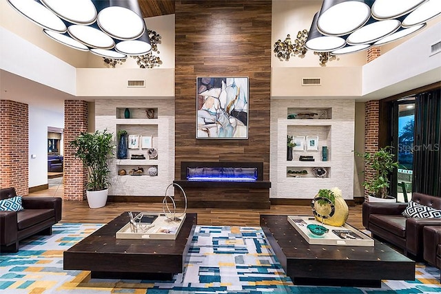 living area featuring visible vents, a fireplace, and a high ceiling