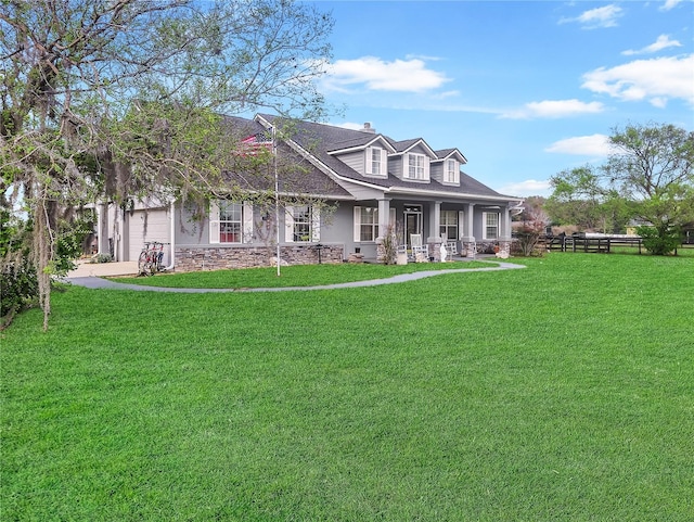 new england style home featuring a garage, a porch, and a front yard