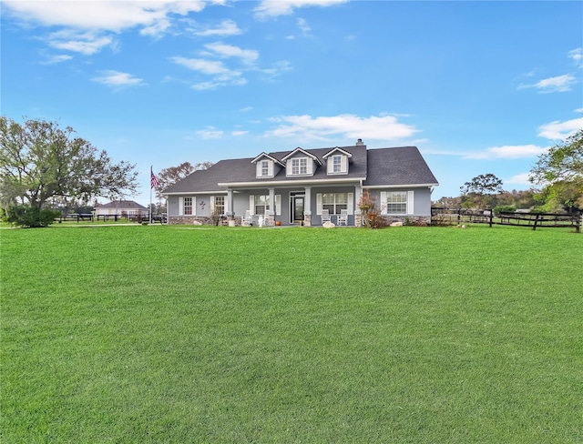 new england style home with a chimney, fence, a porch, and a front yard