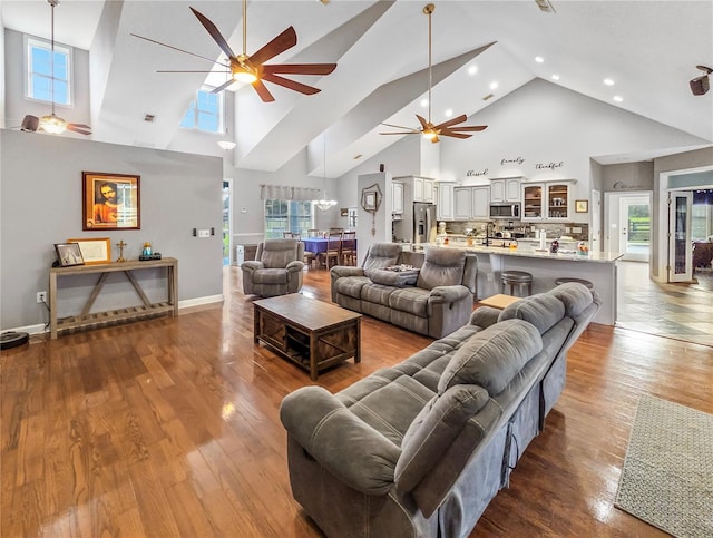 living area with a healthy amount of sunlight, ceiling fan, and wood finished floors