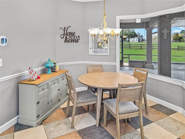 dining space with a chandelier and baseboards