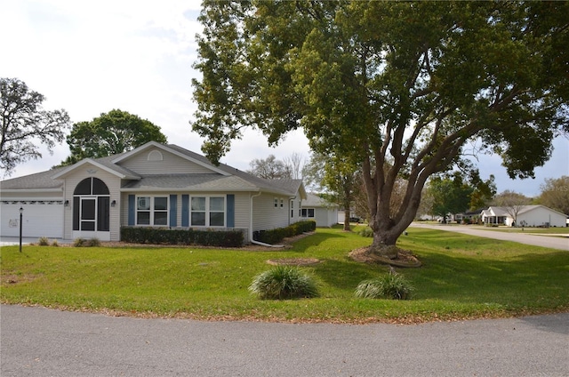 ranch-style home featuring an attached garage, a front lawn, and concrete driveway