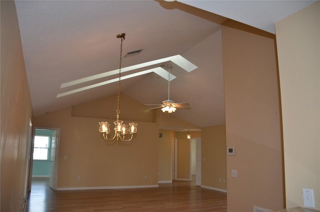 unfurnished room with visible vents, lofted ceiling with skylight, wood finished floors, baseboards, and ceiling fan with notable chandelier