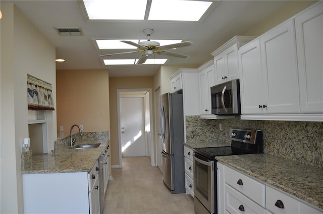 kitchen with visible vents, decorative backsplash, appliances with stainless steel finishes, white cabinets, and a sink