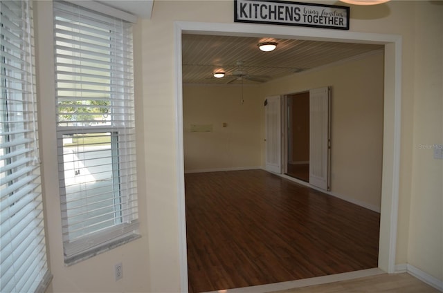 spare room featuring ceiling fan, baseboards, and wood finished floors