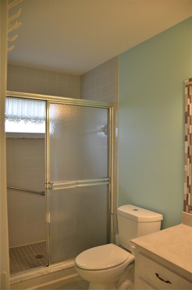 full bath featuring vanity, a shower stall, and toilet