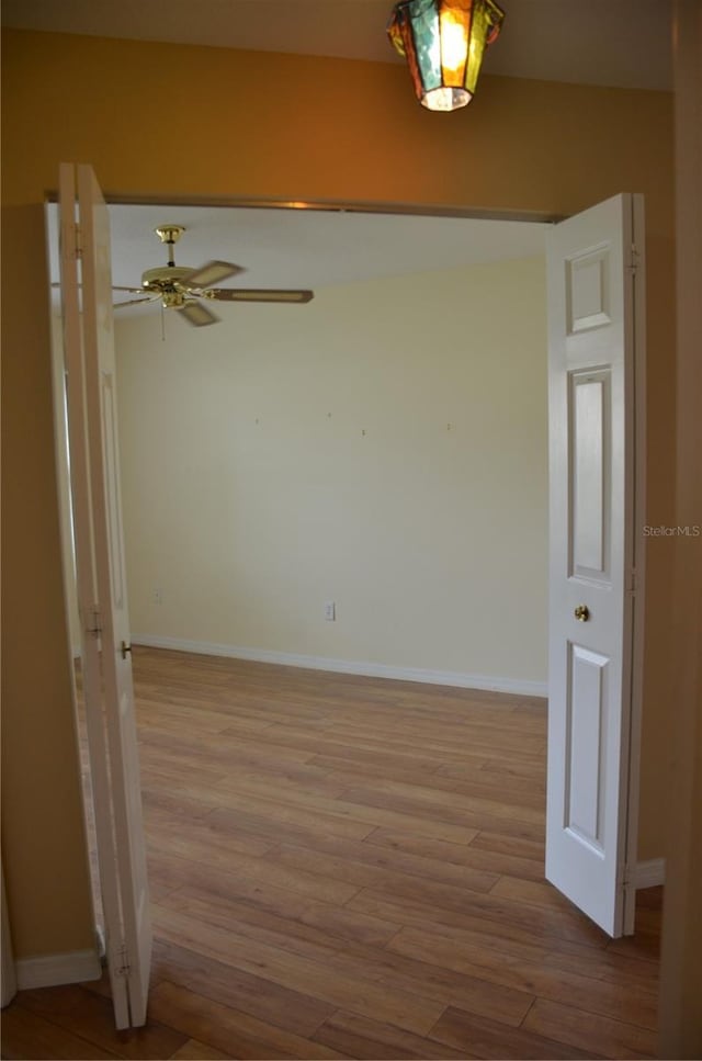 unfurnished room featuring baseboards, ceiling fan, and light wood-style floors