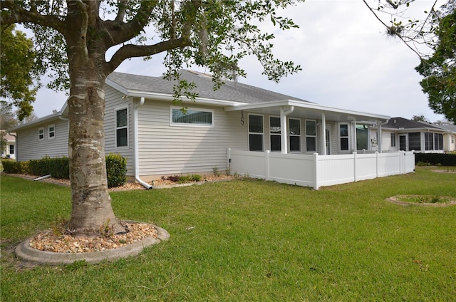 back of house featuring a lawn and fence