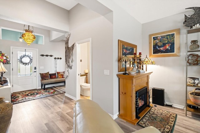 entryway featuring light wood-type flooring, baseboards, and a glass covered fireplace