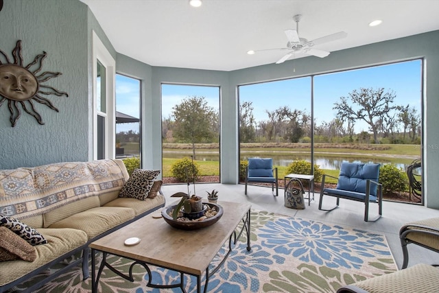 sunroom / solarium featuring a water view, plenty of natural light, and ceiling fan