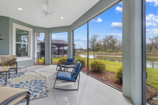 sunroom with a water view and a ceiling fan