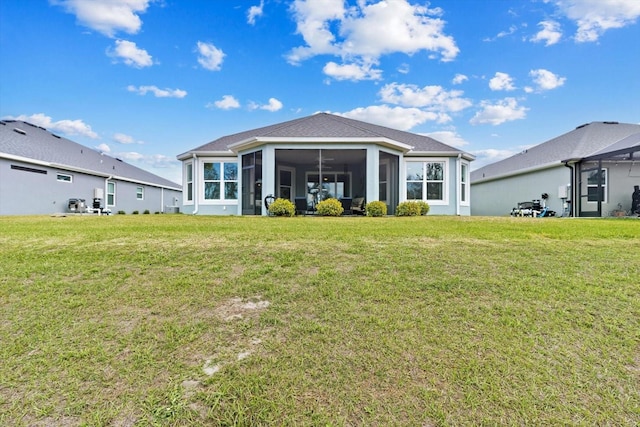 back of house featuring a sunroom, a lawn, and stucco siding