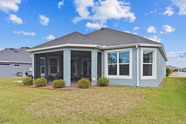 rear view of house featuring a sunroom, roof with shingles, stucco siding, and a yard