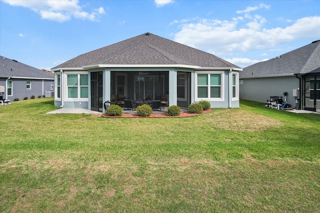 rear view of property with roof with shingles, a yard, stucco siding, a sunroom, and a patio area