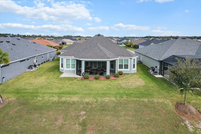 rear view of house with a lawn, roof with shingles, a patio area, and a residential view