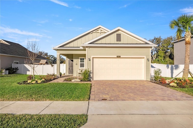 view of front of home featuring board and batten siding, decorative driveway, fence, and an attached garage