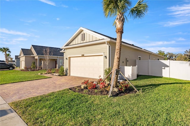 exterior space featuring decorative driveway, fence, board and batten siding, and a yard