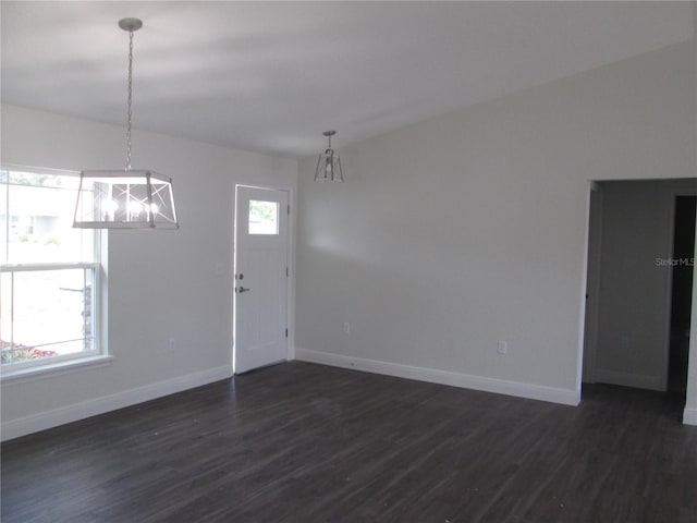 interior space with dark wood-type flooring, baseboards, and a notable chandelier