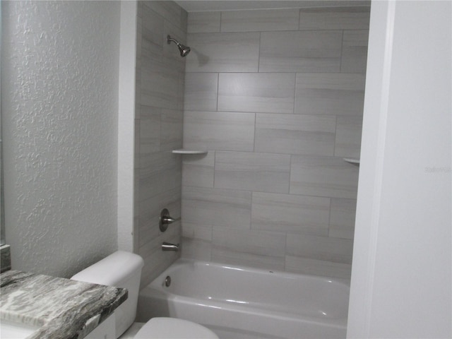 bathroom with toilet, a textured wall, vanity, and tub / shower combination