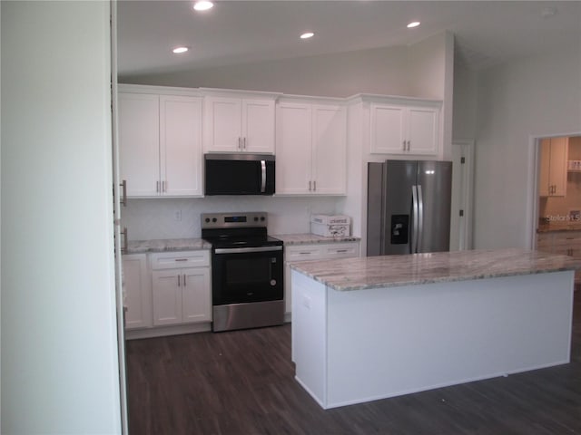kitchen featuring a center island, white cabinets, stainless steel appliances, dark wood finished floors, and lofted ceiling