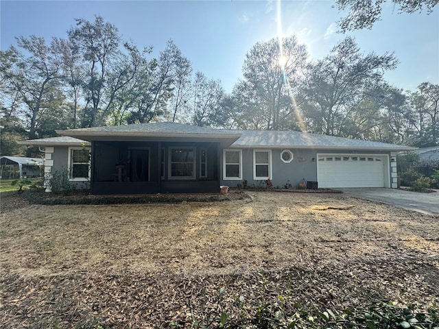 ranch-style house with an attached garage, covered porch, driveway, and stucco siding