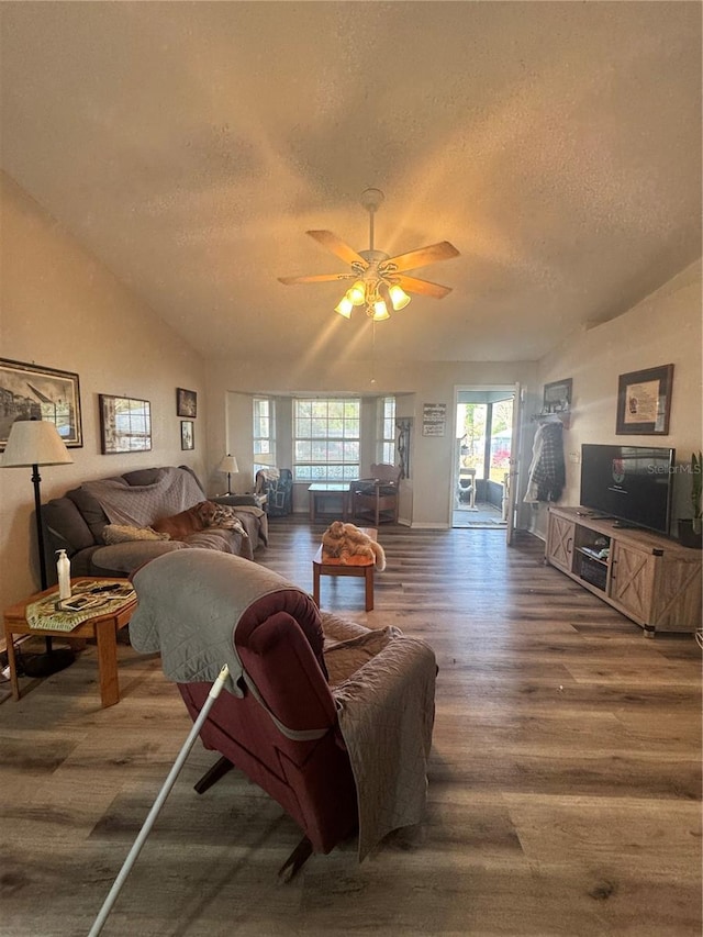 living room featuring a textured ceiling, wood finished floors, and lofted ceiling