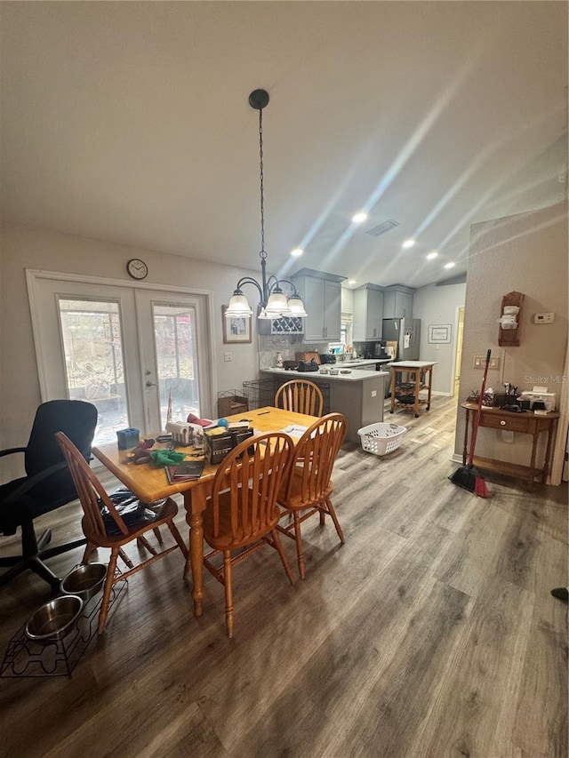 dining space featuring light wood-type flooring, lofted ceiling, and french doors