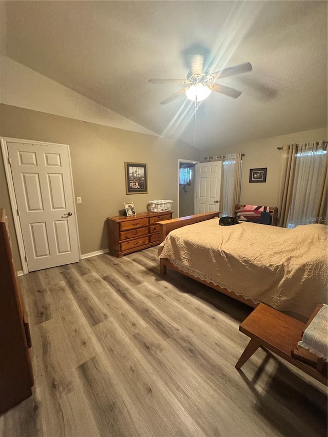 bedroom featuring lofted ceiling, ceiling fan, baseboards, and wood finished floors