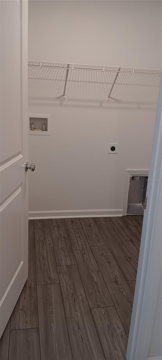 laundry area featuring hookup for a washing machine, electric dryer hookup, wood finished floors, laundry area, and baseboards