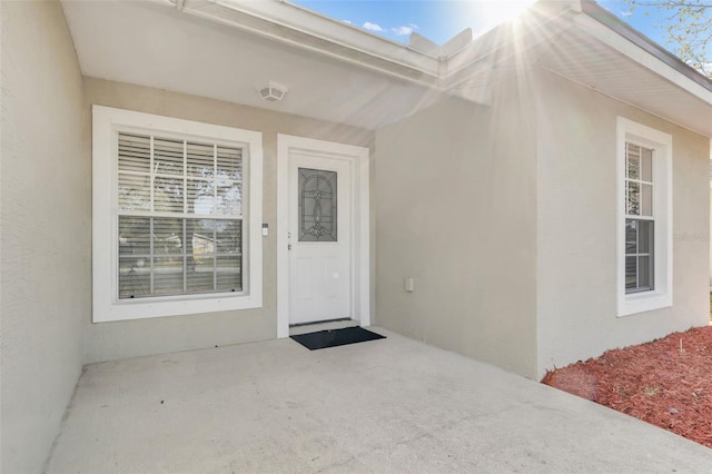 entrance to property with stucco siding