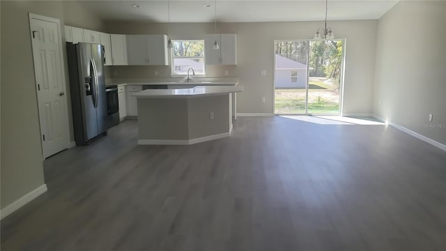 kitchen with white cabinets, light wood-type flooring, stainless steel refrigerator with ice dispenser, and light countertops