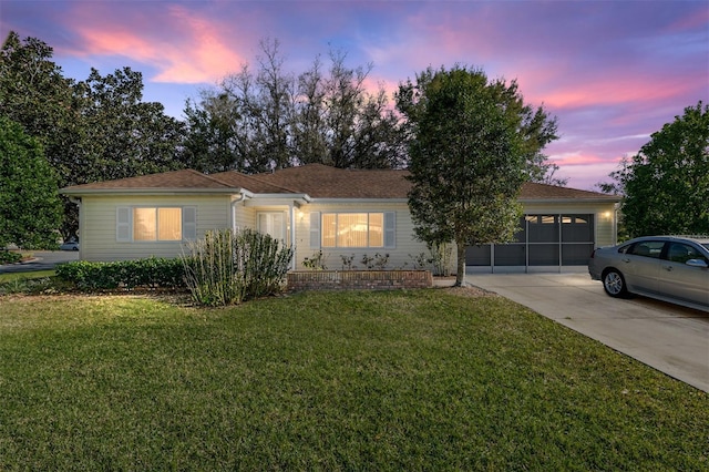 ranch-style house with a garage, concrete driveway, and a front yard