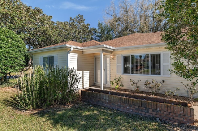 view of front of house with a front yard and roof with shingles