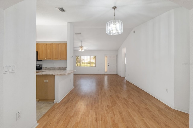 kitchen featuring visible vents, light wood finished floors, hanging light fixtures, light countertops, and ceiling fan with notable chandelier