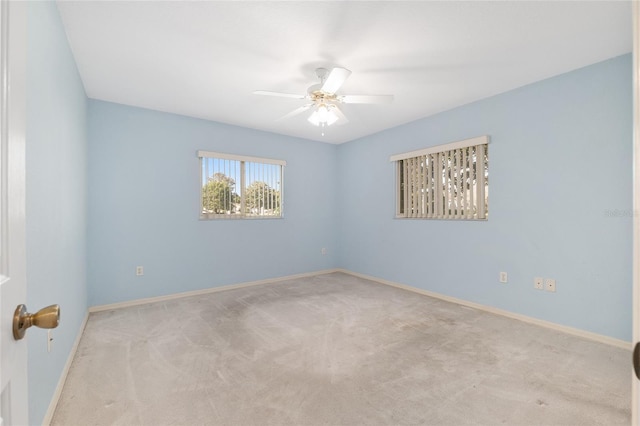 carpeted empty room with baseboards and ceiling fan