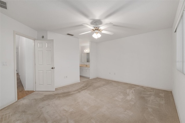 unfurnished bedroom with ceiling fan, light colored carpet, visible vents, and connected bathroom