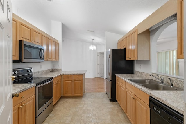 kitchen featuring visible vents, a peninsula, a sink, light countertops, and appliances with stainless steel finishes