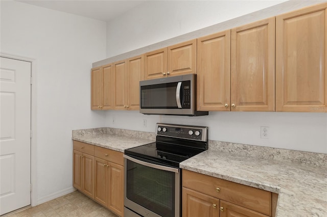 kitchen featuring stainless steel appliances, baseboards, and light floors