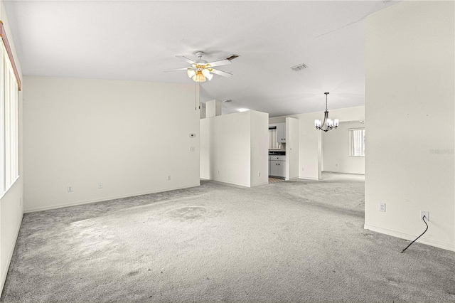 unfurnished living room with light carpet, lofted ceiling, visible vents, and ceiling fan with notable chandelier