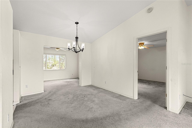 unfurnished dining area with ceiling fan with notable chandelier, carpet, lofted ceiling, and baseboards